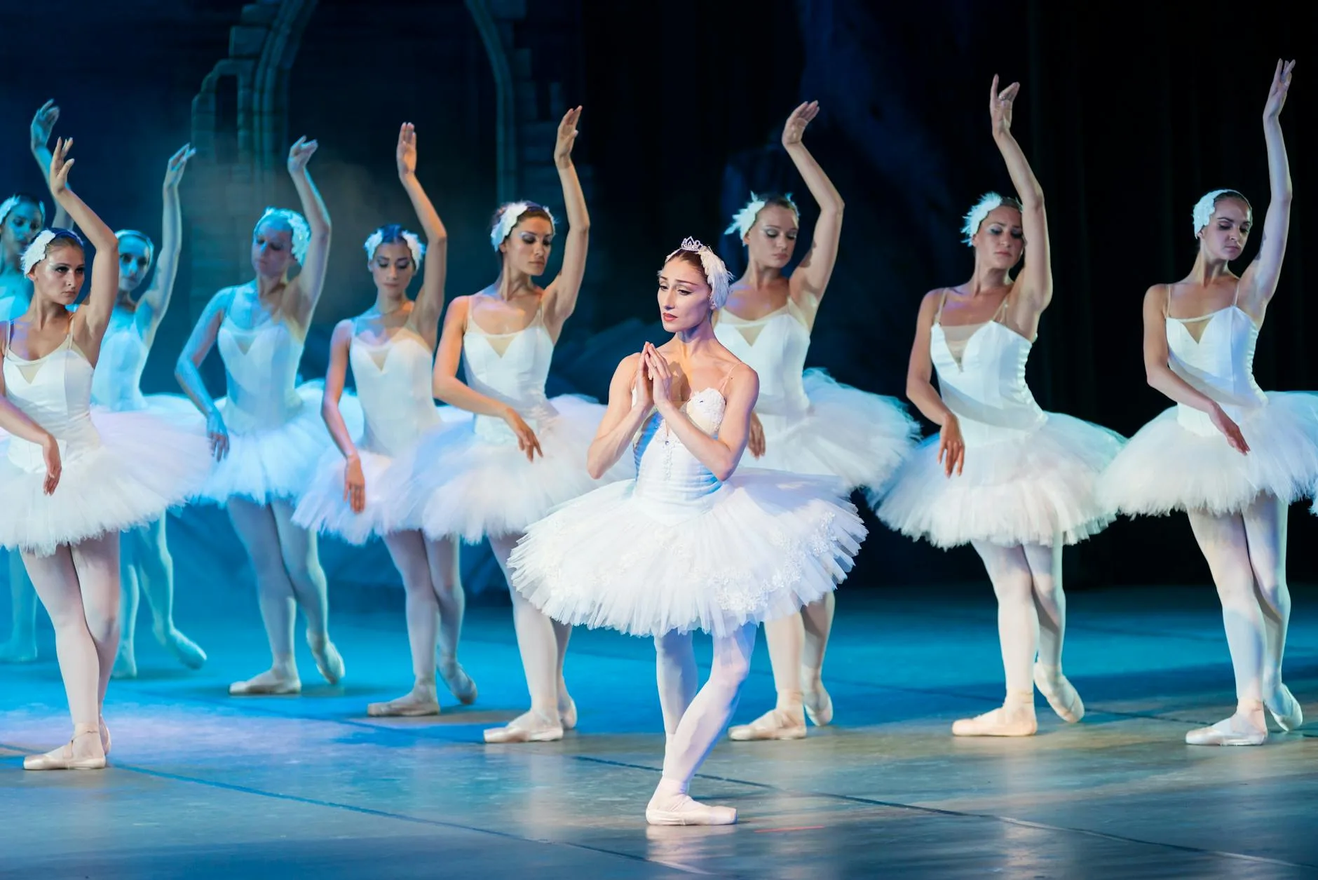 Baletnice w klasycznych tutus tańczą Jezioro łabędzie na scenie